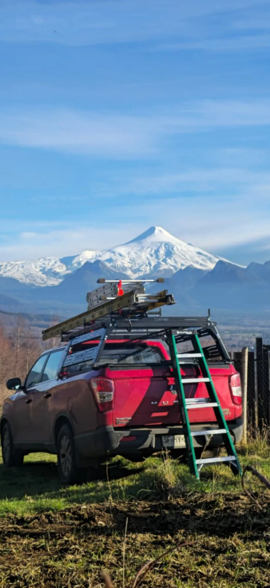 Camioneta de terreno de SoftNet Chile, equipada con escalera y herramientas, frente al volcán Villarrica